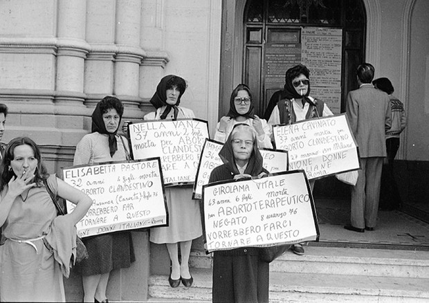 All'ingresso della chiesa Valdese, manifestanti con il capo coperto da un fazzoletto nero,  esibiscono cartelli con i nomi di donne, morte a causa di aborti clandestini, a difesa della legge 194 - Roma, 10 maggio 1981 © ANSA/OLDPIX