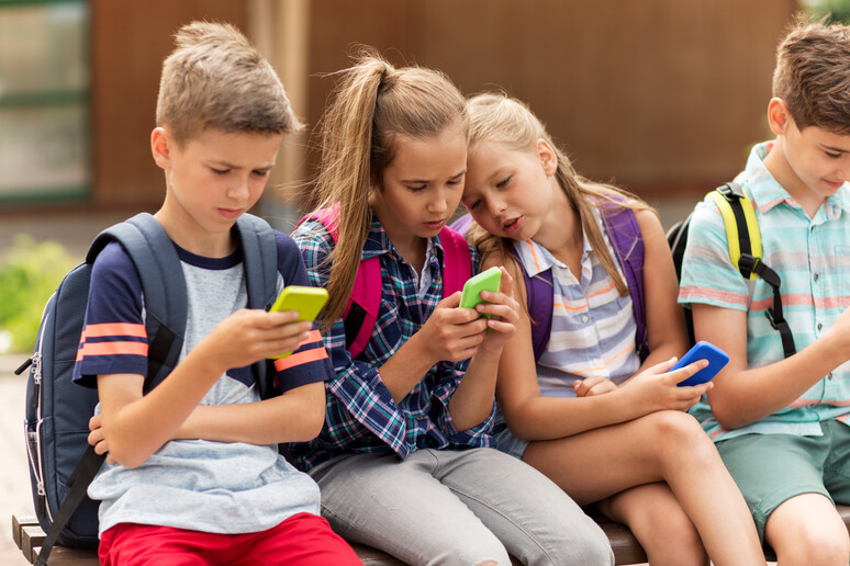 Bambini di scuola elementare con gli smartphone. foto iStock. - RIPRODUZIONE RISERVATA